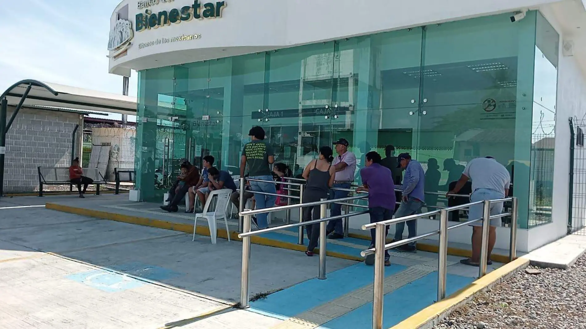 personas haciendo fila en banco bienestar